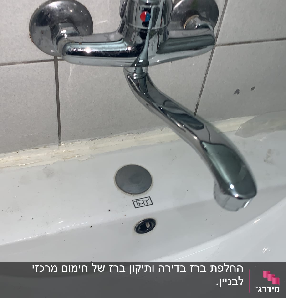 ברז כרום מותקן על קיר מעל כיור לבן